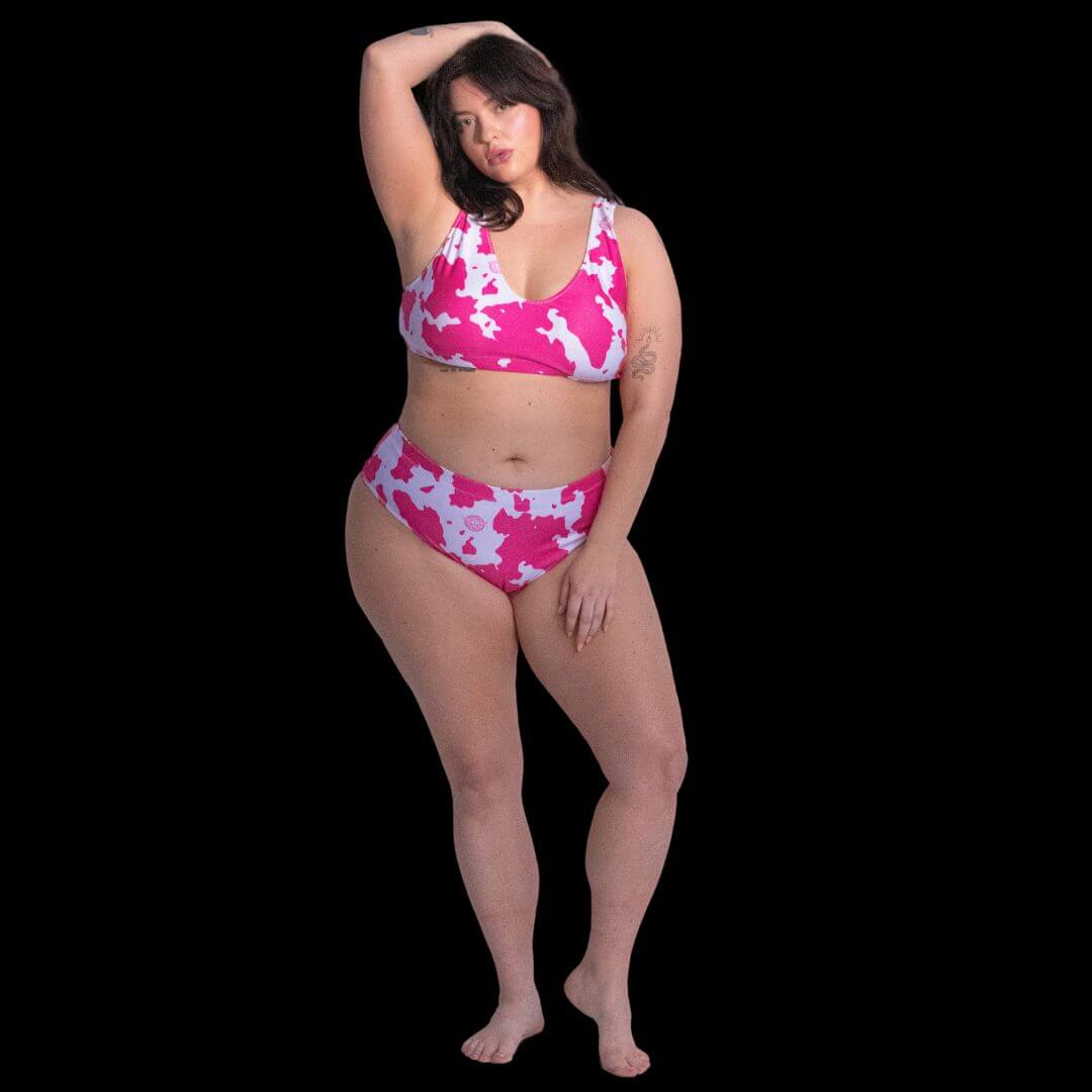 Woman in black and white cow print bikini standing confidently at pool party showing how high-waisted design flatters figure at summer events and music festival water activities all day