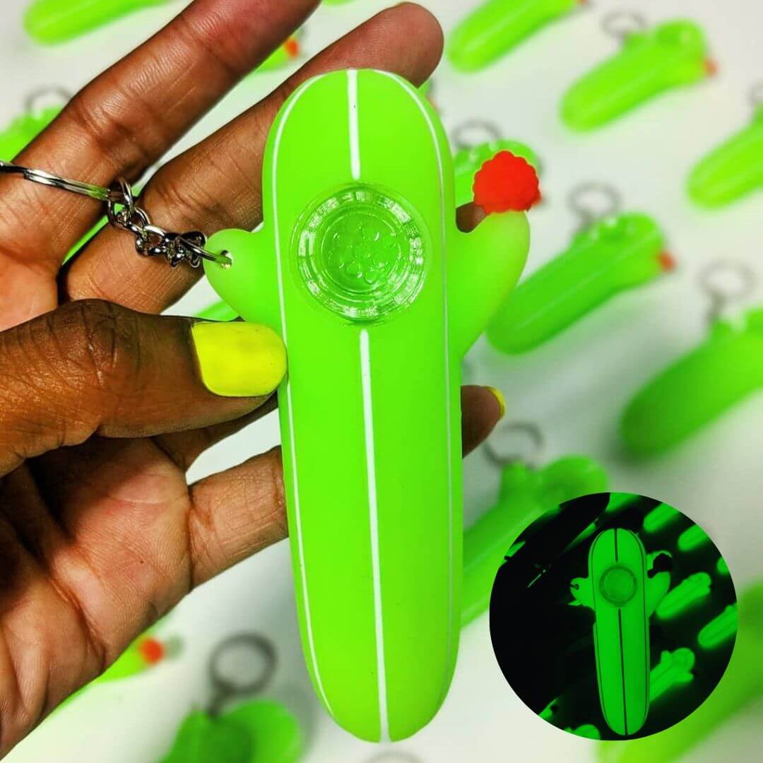 Multiple green cactus pipes showcasing glow-in-the-dark feature and keychain attachment perfect for outdoor party accessories and festival gear that combines practicality with fun novelty design
