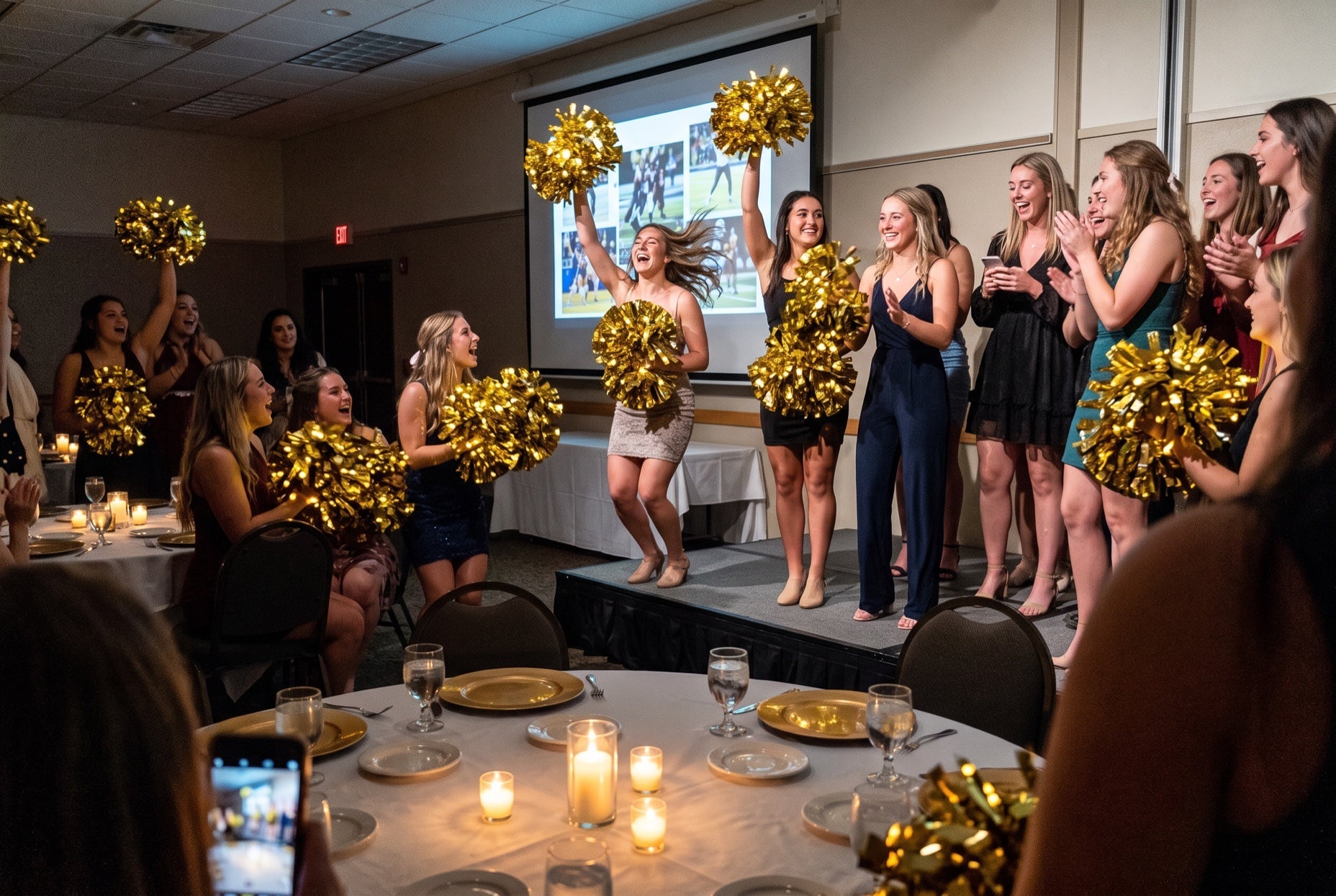 Light up LED pom poms glowing gold at an end-of-season college cheer banquet