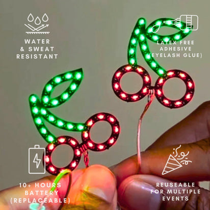 Package of green and red LED cherry face stickers - Retail display of illuminated fruit jewelry showing color options for kawaii fashion, statement makeup, and collectible accessories