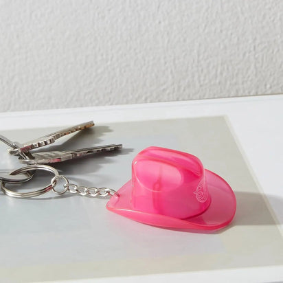 Pink cowboy hat keychain bottle opener on set of keys demonstrating practical festival accessory for camping and outdoor concerts