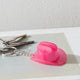 Pink cowboy hat keychain bottle opener on set of keys demonstrating practical festival accessory for camping and outdoor concerts