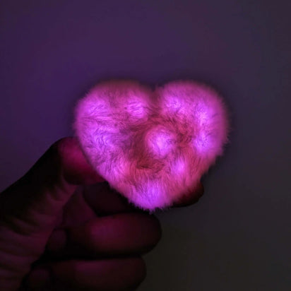 Pink LED heart fuzzy hair clip held in hand - Illuminated kawaii hair accessory for sweet sixteen parties, date nights, princess-themed events, and social media content creation