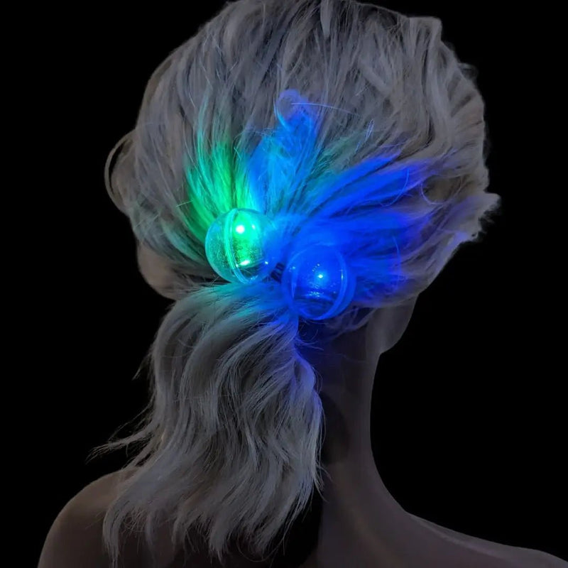 Neon Cowboys LED hair ties glowing blue and green knocker beads in a low ponytail at night, color changing light up hair accessories for parties, music festivals, raves, EDM girl outfits and glow parties, Neon Cowboys
