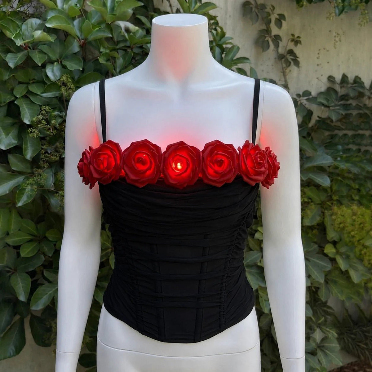 LED Rose Corset in black with glowing red LED roses on a mannequin — light-up rose corset for burlesque, showgirls, drag, rave & festival performance