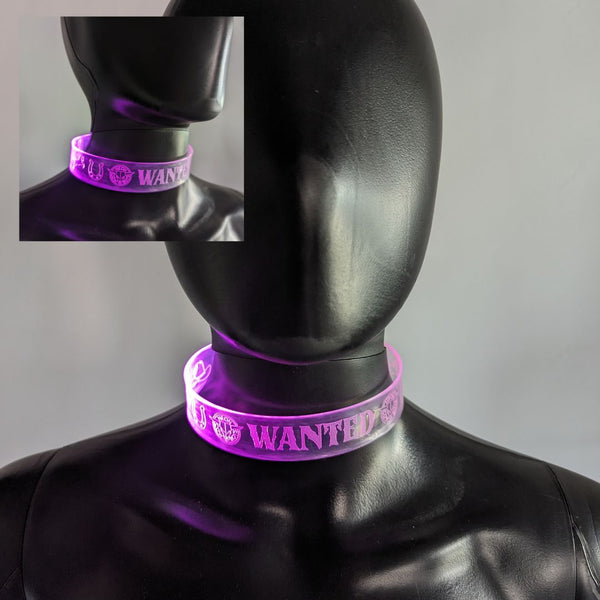 Person wearing purple light up WANTED choker at EDM music festival rave party with glow in the dark neon accessories perfect for nighttime events and Halloween costume parties or club outfits