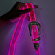Close-up of pink light up fanny pack with adjustable strap demonstrating water-resistant features for outdoor festivals and rainy events