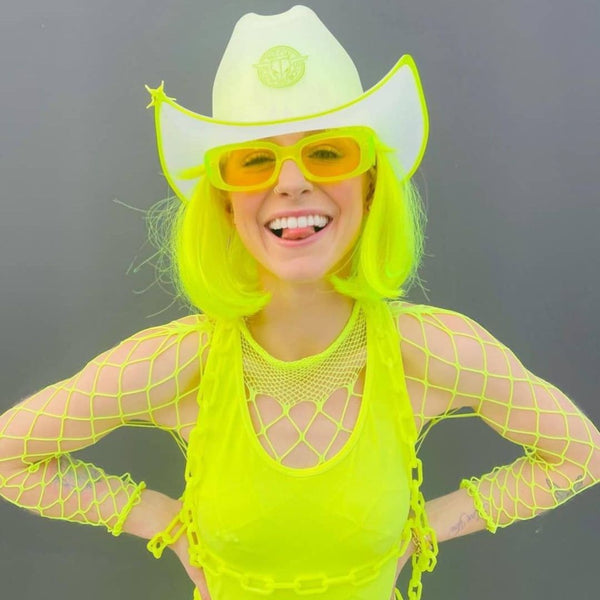 Smiling woman in neon yellow fishnet and a white clear plastic light up cowboy hat with yellow sunglasses, neon cowboy hat and glow cowboy hat for raves, music festivals, and EDM events, Neon Cowboys
