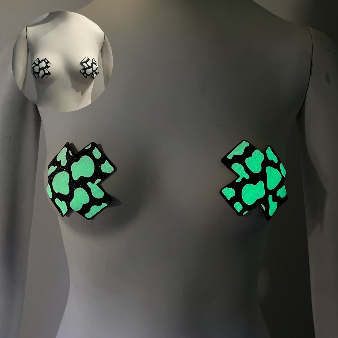 Woman wearing green glow in the dark cow print X-shaped nipple stickies perfect for western themed parties rodeos and country music festivals