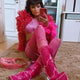 Model in all pink outfit with matching LED transparent boots and feather boa creating coordinated party look for birthday celebrations nightlife events and themed parties