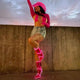 Woman wearing hot pink glowing transparent boots with denim shorts showcasing versatile festival footwear for outdoor music events and summer concerts