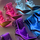 Collection of multiple color LED boots including pink purple and blue options showing variety of light-up footwear for different event themes