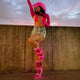 Woman wearing hot pink glowing transparent boots with denim shorts showcasing versatile festival footwear for outdoor music events and summer concerts