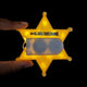 Gold Yellow LED sheriff badge star held in hand closeup - Detailed view of 3D printed illuminated police accessory with brooch pin for easy attachment to costumes and outfits