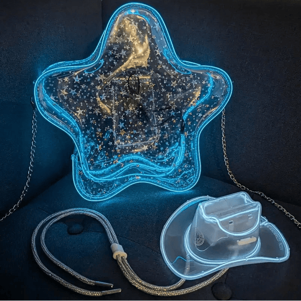 Transparent Clear Star Purse for Women, a clear star bag glowing blue LED beside a light up mini neon cowboy hat on a dark couch, a clear bag concert policy purse for football stadiums and venues, a light up crossbody bag and perfect gift for space cowgirl Halloween costumes, bachelorettes and music festivals with a glowing mini hat, Neon Cowboys