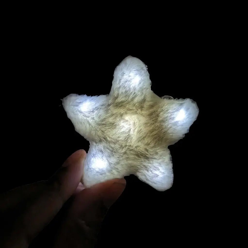 White LED star fuzzy hair clip held in hand - Illuminated star-shaped hair accessory for bridal styles, angel costumes, winter formals, and ethereal fashion statements
