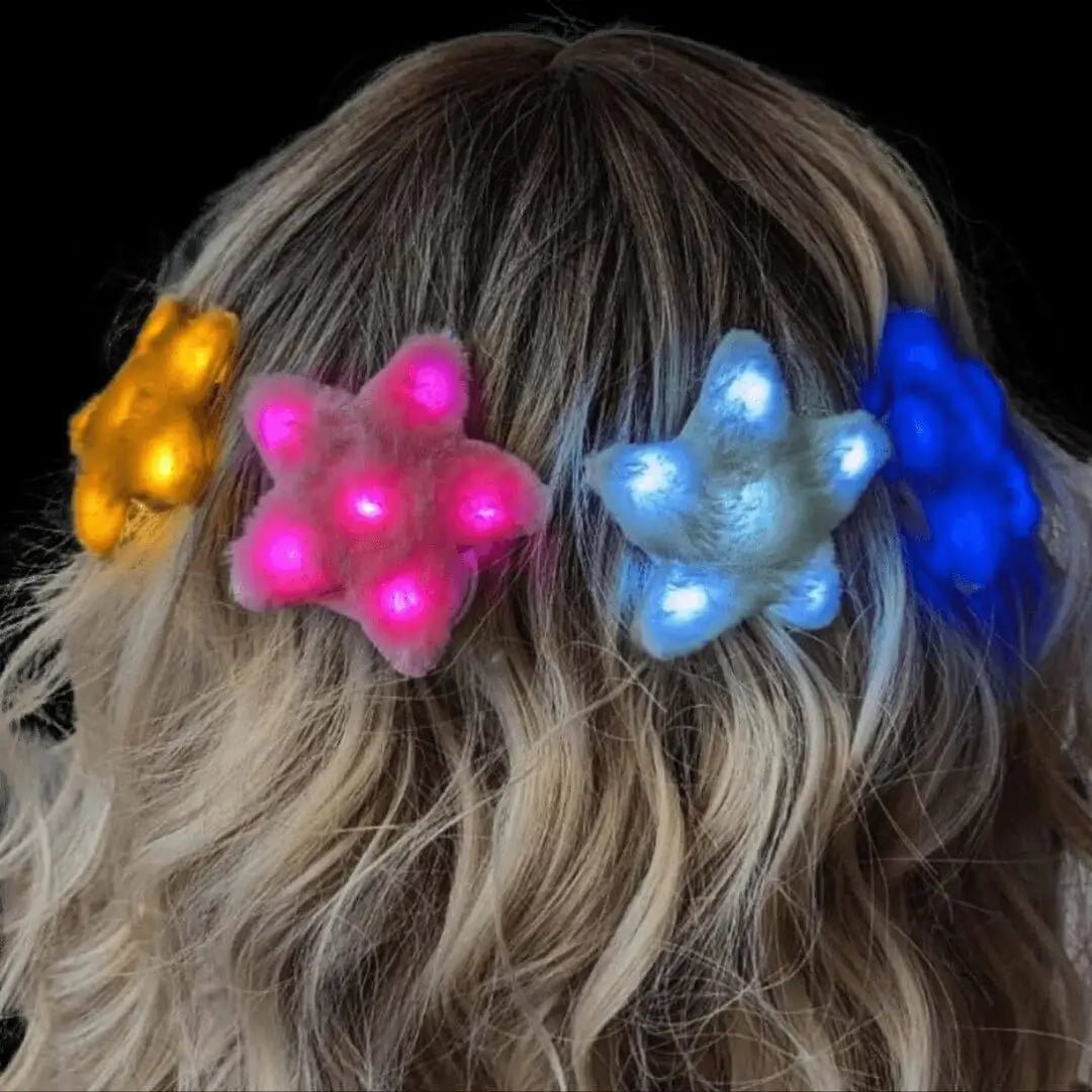 Woman wearing multiple colorful LED star fuzzy hair clips - Illuminated star-shaped hair accessories in pink, blue, and gold for festivals, concerts, celestial-themed parties, and Y2K fashion looks