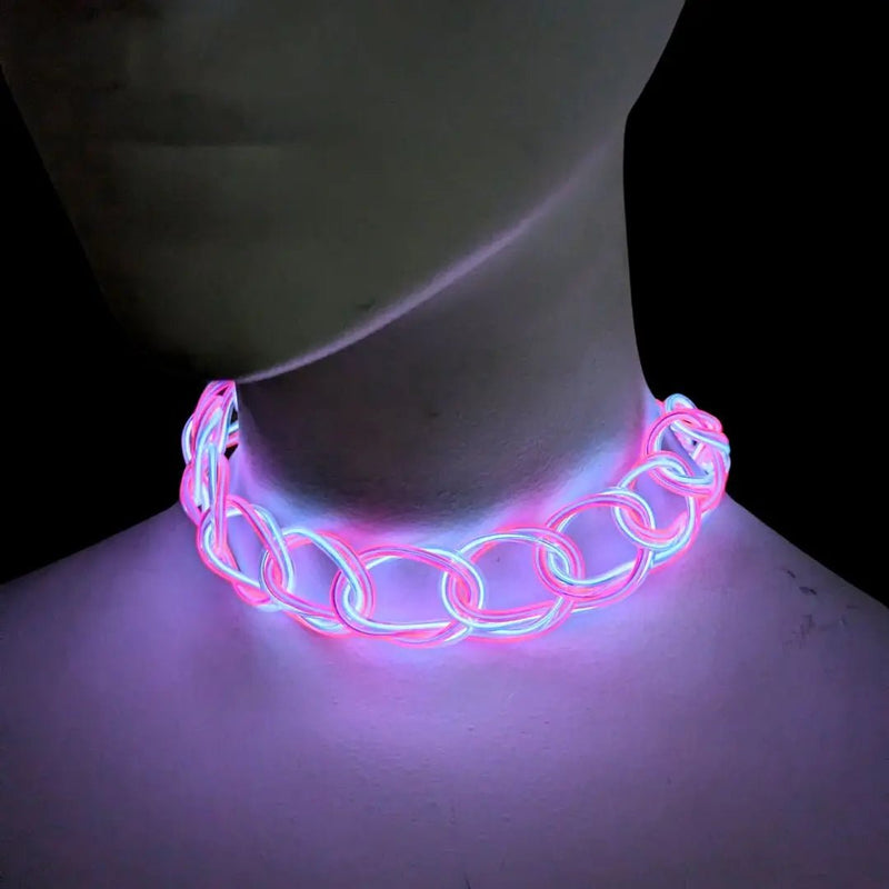 Pink glowing Y2K LED choker on a mannequin neck in the dark, an illuminated chain link light up necklace and retro 2000s fashion jewelry, a light up rave accessory and Y2K choker for glow parties, music festivals and concerts, Neon Cowboys