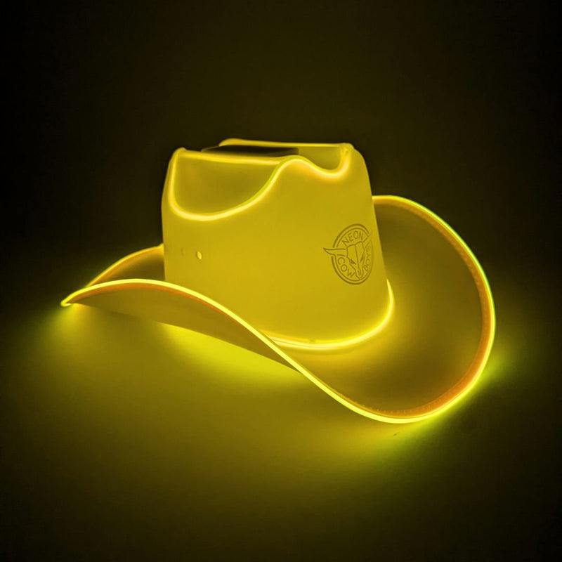 Yellow glowing LED light-up cowboy hat with illuminated brim on a dark studio surface, a neon cowboy hat and glow in the dark cowgirl hat perfect for Nashville bachelorette parties, western celebrations, country concerts and rodeos, Neon Cowboys