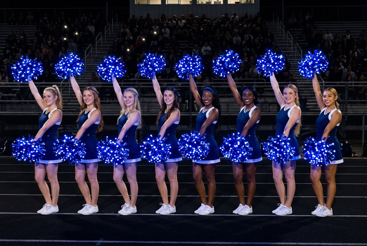 High school cheer squad holding glowing blue LED light-up pom poms on the track at a night football game