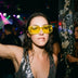 Woman at a nightclub wearing yellow tinted LED light up party sunglasses over a sequin top, glowing cyberpunk led glasses and festival sunglasses for raves, EDM concerts, and glow parties, Neon Cowboys