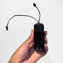 Hand holding black Two Prong Inverter battery pack with connecting wire - Power supply for LED accessories with convenient portable design