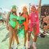 Group of women in neon bodysuits wearing LED cowboy hats at outdoor festival - Bright colored light-up western headwear for Coachella, EDM festivals, costume parties, pride events, and desert gatherings