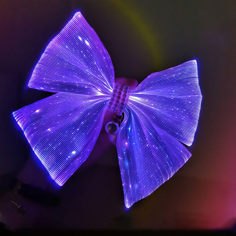 Light-up cheer bow glowing violet with a rhinestone center, LED hair bow for cheerleading and competition teams