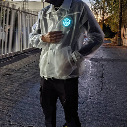 Man walking at dusk wearing light-up horse jacket with glowing animated design showing 18+ hours of rechargeable illumination for nighttime events