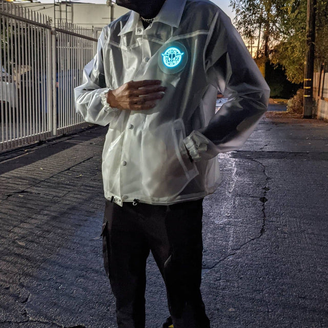 Man walking at dusk wearing light-up horse jacket with glowing animated design showing 18+ hours of rechargeable illumination for nighttime events