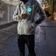 Man walking at dusk wearing light-up horse jacket with glowing animated design showing 18+ hours of rechargeable illumination for nighttime events