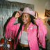 Animated Starlight Jacket with Fringe, smiling woman in a pink cowboy hat and pink LED star fringe jacket at a party with a tinsel backdrop, a light up jacket and disco cowgirl stagewear for bachelorette parties, festivals and raves, Neon Cowboys