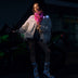 Animated Starlight Jacket with Fringe, model by a motorcycle in a white LED star fringe jacket holding a glowing pink light-up bandana at night, a light up jacket and led costume for festival dancers, raves, Coachella and Pride, Neon Cowboys