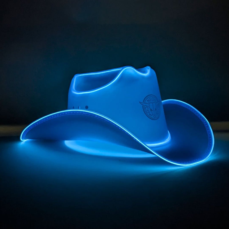 Blue LED light-up cowboy hat glowing on a dark studio surface at night, a blue light up cowboy hat, neon cowboy hat, LED cowboy hat, great for luxury event planning western themed parties and fashion celebrations, loved for rodeos & country concerts, Neon Cowboys