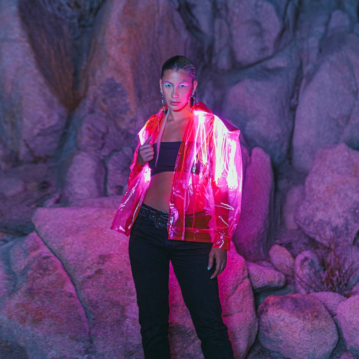 Woman wearing vibrant pink LED fringe jacket at night creating eye-catching movement for music festivals EDM concerts and nightclub parties