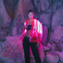 Woman wearing vibrant pink LED fringe jacket at night creating eye-catching movement for music festivals EDM concerts and nightclub parties
