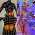 JT from City Girls wearing custom light up belt buckle with purple hair and checkered outfit during music video showcasing trending festival fashion accessories