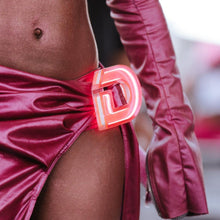 Close-up of Doechii's pink illuminated belt buckle with custom letter D showing detailed craftsmanship of personalized LED accessories for concert outfits