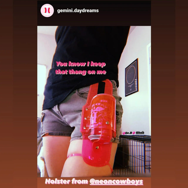 Person wearing orange drink holder clipped to pants pocket for music festivals and outdoor concert convenience