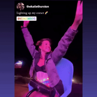 Female DJ wearing programmable LED corset in pink lighting while performing at nightclub rave party, showcasing light up stage fashion