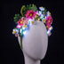 Floral pipe cleaner headband by Neon Cowboys on a white mannequin, a crown of handmade pink and white daisies and green fern leaves glowing with cool white LED fairy lights (included, you add them yourself), a light-up flower crown for festivals, raves, fairy and Halloween costumes