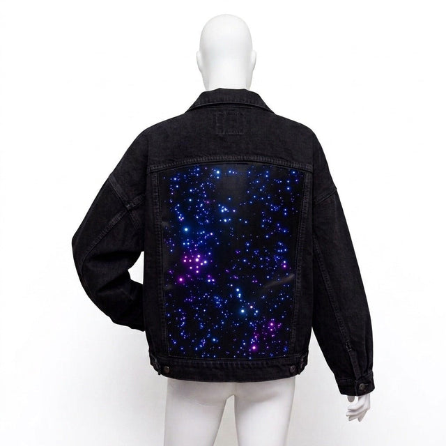 Black-wash Neon Cowboys Galaxy Denim Jacket back with an unlit blue and purple starfield print panel on a mannequin, a glowing led starfield light up denim jean jacket for music festivals and concerts, a space cowgirl and disco cowgirl statement piece for raves, Neon Cowboys