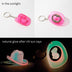 Pink cowboy hat bottle opener keychain showing daylight appearance and glowing effect after UV light exposure for nighttime festivals