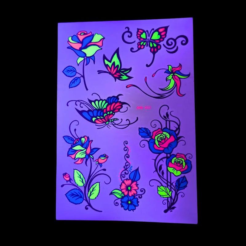 One glow in the dark temporary tattoo sheet illuminated with UV light, colorful neon rose, butterfly and floral designs glowing brightly, UV reactive body art and glow in the dark tattoos for music festivals, raves, concerts and parties, Neon Cowboys