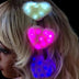 Woman with three LED heart fuzzy hair clips in different colors - Illuminated kawaii hair accessories in blue, pink, and white for festivals, raves, cosplay events, and birthday celebrations