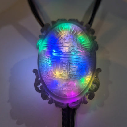 Multicolored LED bolo tie close-up in dark setting - 3D printed resin western accessory with vibrant illumination for line dancing events, nightclub outings, and country-themed parties