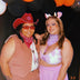 Two women in cowboy hats and bikinis posing together at country western themed festival demonstrating friendship outfit coordination for summer music events and themed pool parties