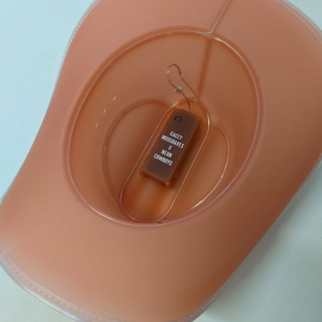 Inside view of pink Kacey Musgraves x Neon Cowboys LED hat showing battery pack and switch for country concert accessories and light up festival fashion