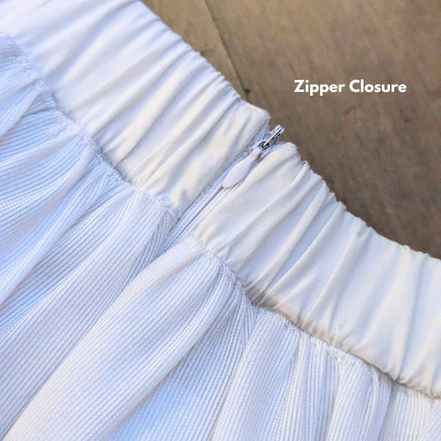 Close-up of a white Neon Cowboys LED 3 Layer Tiered Skirt waistband showing the zipper closure detail, a light up dress and led rave outfit stagewear for go-go dancers, burlesque performers and festival dancers, a versatile festival outfit for raves, EDM concerts and Pride, Neon Cowboys