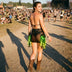 Woman in cowboy boots wearing a black LED fringe garter skirt glowing green at an outdoor festival, a light up garter and glowing fringe stagewear for go-go dancers, festival dancers and burlesque performers, perfect for music festivals, raves, Coachella and Pride, Neon Cowboys